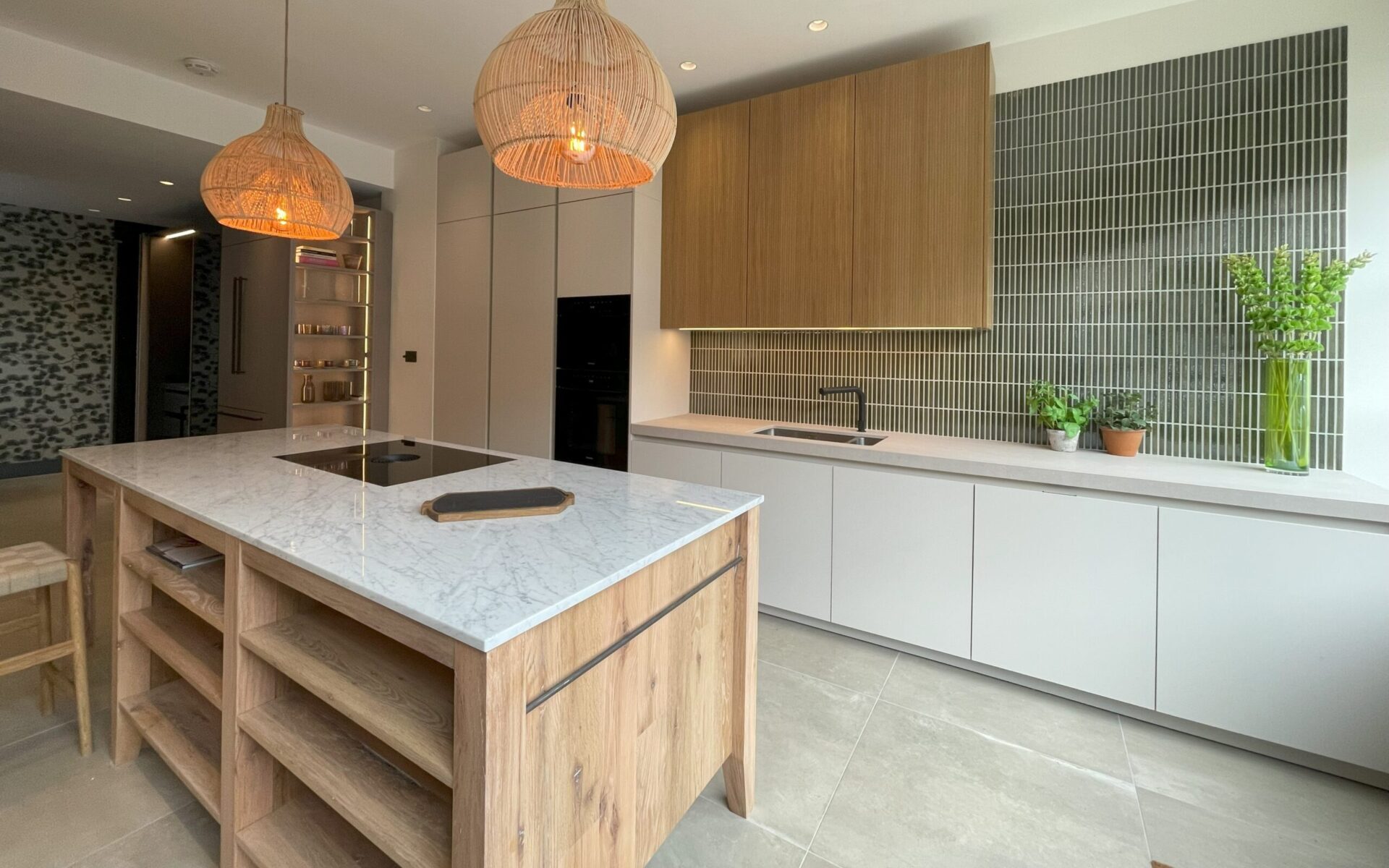 Kitchen showroom with wood island and green tile backsplash